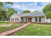 Charming ranch-style home with a red brick walkway, manicured lawn, and inviting curb appeal at 5601 Carmel Station Ave, Charlotte, NC 28226