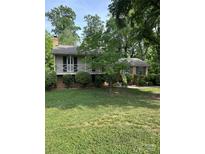 Charming home with a covered front porch and manicured lawn surrounded by mature trees at 5938 Sharon Rd, Charlotte, NC 28210
