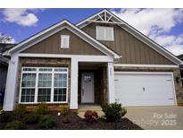 Inviting home featuring stone accents, a white garage door, and a well-manicured front yard, offering appealing curb appeal at 6642 Star Dr, Sherrills Ford, NC 28673