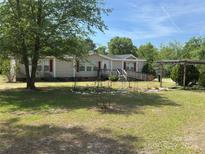 Charming ranch-style home with beige siding, red shutters, a ramp to the front door, and a spacious front yard at 7494 Flat Creek Rd, Lancaster, SC 29720