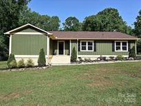 Charming single-story home featuring green siding, dark shutters, and a well-manicured lawn at 9565 Man O War Rd, Indian Land, SC 29707