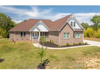 Charming brick home featuring a well-manicured lawn and inviting front porch at 115 Woodward Way, Iron Station, NC 28080