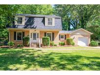 Charming brick home featuring a manicured lawn and beautiful landscaping at 1324 Princeton Ave, Gastonia, NC 28054