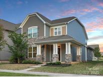 Charming two-story home boasting stone accents, inviting front porch, and professional landscaping at 13332 Caite Ridge Rd, Davidson, NC 28036