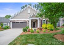 Charming home featuring manicured lawn, stone accents, attached two-car garage and covered front entryway at 16112 Lakeside Loop Ln, Cornelius, NC 28031