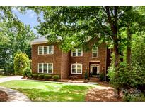 Beautiful two-story brick home with a well-manicured lawn and mature trees at 1654 Scotch Pine Ln, Fort Mill, SC 29708