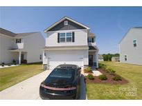 Charming two-story home with a manicured lawn, a car, and an attached two-car garage at 2210 Transatlantic Ave, Charlotte, NC 28215