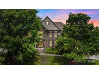 Stunning brick home with lush greenery, elegant architectural details, and a beautifully landscaped front yard at 2817 Bevis Ln, Waxhaw, NC 28173