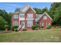 Charming brick two-story home featuring light-colored accents, pristine landscaping, and shuttered windows at 3104 Highgate Dr, Fort Mill, SC 29715