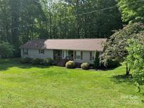 Inviting home with a well-manicured lawn, mature trees, and cozy front porch at 4225 Stewart Rd, Claremont, NC 28610