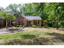 Charming single Gathering home boasts a brick facade, mature trees, and well-manicured lawn at 4234 Woodglen Ln, Charlotte, NC 28226