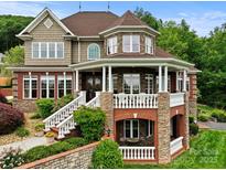 Stunning two-story home showcasing stone and brick accents, a charming porch, and meticulously landscaped surroundings at 6164 Dwayne Starnes Dr, Hickory, NC 28602