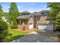 Traditional brick home featuring a three-car garage and well-maintained landscaping on a sunny day at 7365 Gabriel St, Sherrills Ford, NC 28673