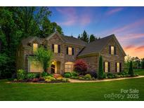 Beautiful two-story brick home with manicured landscaping and a warm, inviting entryway at 801 Hidden Pond Ln, Waxhaw, NC 28173