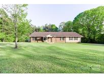 Ranch-style home featuring a brick facade, shutters, and a spacious lawn with mature trees at 856 Skyline Dr, Chester, SC 29706