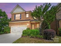Charming two-story brick home with a well-manicured lawn and attached two-car garage at 9735 Wheatfield Rd, Charlotte, NC 28277