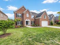 Charming two-story brick home featuring a well-manicured lawn and attached two car garage at 9923 Paradise Ridge Rd, Charlotte, NC 28277