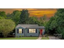 Charming single-story home featuring a red front door and manicured landscaping at 1100 Mona Dr, Charlotte, NC 28206