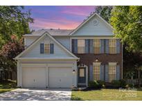 Charming two-story home with brick and siding, complemented by a manicured lawn and a two-car garage at 11807 Hawick Valley Ln, Charlotte, NC 28277