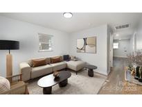 Inviting living room features a neutral sectional sofa, minimalist decor, and modern light fixtures at 1211 N Boyce St, Gastonia, NC 28052