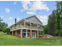 Expansive two-story home featuring a charming wooden deck, a spacious lawn, and inviting outdoor spaces for leisure and enjoyment at 281 Emerald Shores Rd, Mount Gilead, NC 27306