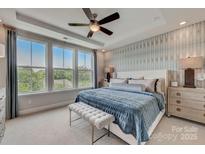 Beautiful main bedroom features large windows, tray ceilings, ceiling fan and ensuite bathroom at 3124 Stelfox St, Charlotte, NC 28262