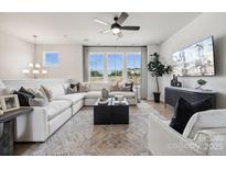 Bright living room featuring a comfortable sectional sofa, modern decor, and large windows at 3128 Stelfox St, Charlotte, NC 28262