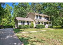 Charming two-story home with a well-manicured lawn, front porch, and lush landscaping at 335 Bob White Run, Salisbury, NC 28147