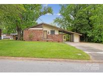 Charming single-story home featuring a brick facade, carport, and well-maintained lawn at 3828 Delgany Dr, Charlotte, NC 28215