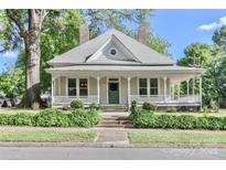Charming single-Gathering home featuring a covered porch, dormer window, landscaped front yard, and traditional architectural details at 531 Walnut St, Statesville, NC 28677
