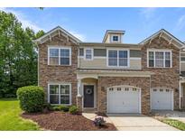 Charming townhome with stone accents, attached garages, manicured lawn, and inviting front entrance at 5621 Tipperlinn Way, Charlotte, NC 28278
