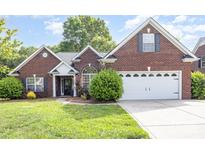 Charming brick home featuring a two-car garage and well-maintained lawn at 5706 Sustar Dr, Monroe, NC 28110