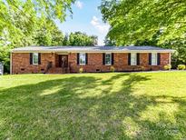 Charming brick home with a large, well-manicured front yard and mature trees at 70 Cumberland Sw Ct, Concord, NC 28025