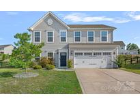 Charming two-story home features a well-maintained front yard, two-car garage, and inviting curb appeal at 7332 Newsome Sw Ct, Concord, NC 28025