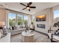 Bright living room with large windows, fireplace, modern ceiling fan, and stylish contemporary furniture and decor at 743 Hoke Ln, Davidson, NC 28036