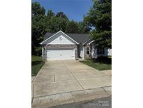 Charming single-Gathering home featuring a stone facade, a two-car garage and a well-manicured front lawn at 8708 Goldfields Dr, Charlotte, NC 28227