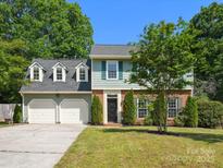 Charming two-story home with a well-manicured lawn, brick accents, and a two-car garage in a desirable neighborhood at 9430 Peckham Rye Rd, Mint Hill, NC 28227