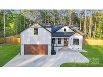 Charming craftsman home boasting board and batten siding, black trim, and a striking wood garage door at 10125 Bethel Church Rd, Midland, NC 28107