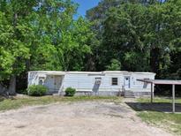 Modest single-story home featuring light blue siding and a practical covered parking area at 1029 Sullivan St, Wadesboro, NC 28170