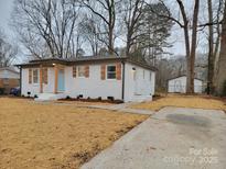 Charming one-story home with white brick, wood accents, and a well-manicured lawn at 106 Greentree Dr, Mount Holly, NC 28120