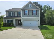 Charming two-story home with a well-manicured lawn, a two-car garage, and a welcoming front entrance at 1071 Bassett Way, Fort Mill, SC 29707