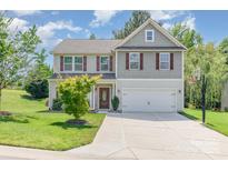 Charming two-story home with a well-manicured lawn and attached two-car garage at 1071 Bassett Way, Fort Mill, SC 29707