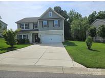 Charming two-story home featuring a well-manicured lawn and a spacious driveway leading to a two-car garage at 1071 Bassett Way, Fort Mill, SC 29707