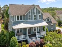 Charming two-story home featuring a covered porch with seating, landscaped yard, and craftsman architecture at 10822 Brandie Meadow Ln, Huntersville, NC 28078
