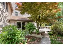 Charming backyard with wooden deck, lush landscaping, and a stone walkway, perfect for outdoor entertaining at 1160 Walton Pl, Salisbury, NC 28146