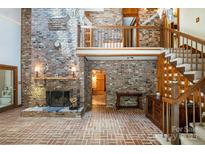 Spacious living room with brick fireplace, brick floors, and second story balcony at 1160 Walton Pl, Salisbury, NC 28146