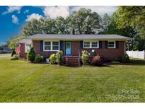 Charming red brick home with manicured lawn and landscaped garden beds, featuring a bright blue front door at 192 Bailey Ave, Rock Hill, SC 29732