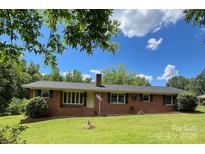 Charming one story brick home with a well-manicured lawn and mature trees at 211 Amos Homesley Rd, Cherryville, NC 28021