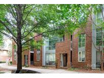 Modern brick townhouse with large windows and mature trees surrounding the property at 226 Magnolia Ave, Charlotte, NC 28203
