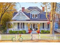 Charming two-story home featuring a welcoming porch, white picket fence, and colorful fall decor for seasonal appeal at 290 Union S St, Concord, NC 28025